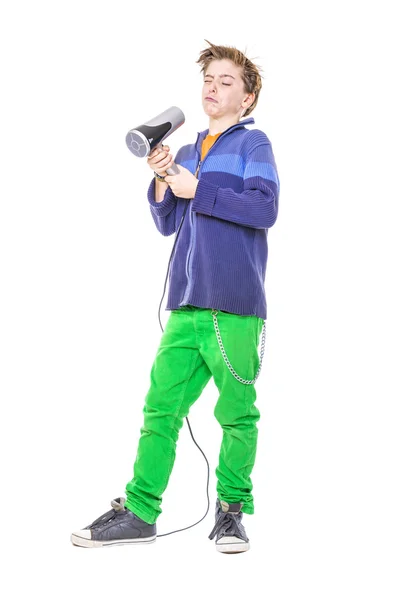 Casual ragazzo adolescente sta combattendo con un asciugacapelli, isolato su wh — Foto Stock