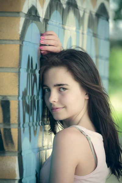 Portrait of a teenager girl leaning on a wall with graffiti — Stock Photo, Image