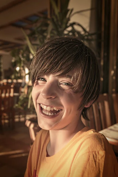 Laughing teenager boy sitting in a restaurant — Stock Photo, Image