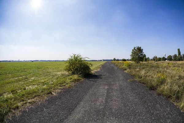 Little road leading to the horizon with meadow around — Stock Photo, Image