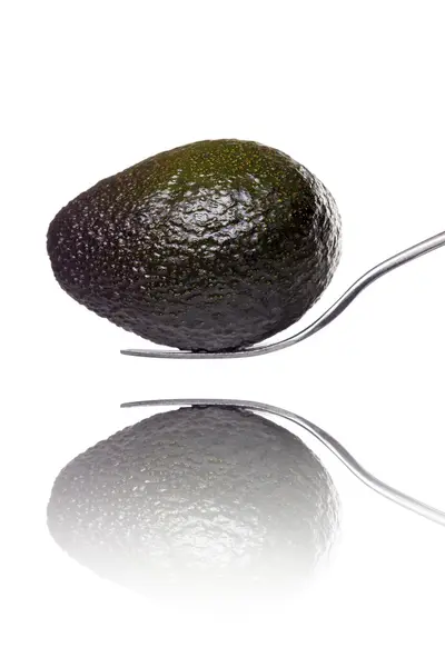 Eine Avocado auf einer Gabel mit Reflexion, isoliert auf weiß — Stockfoto