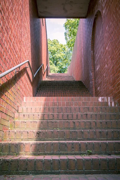 Un túnel como escalera con ladrillos rojos y pasamanos —  Fotos de Stock