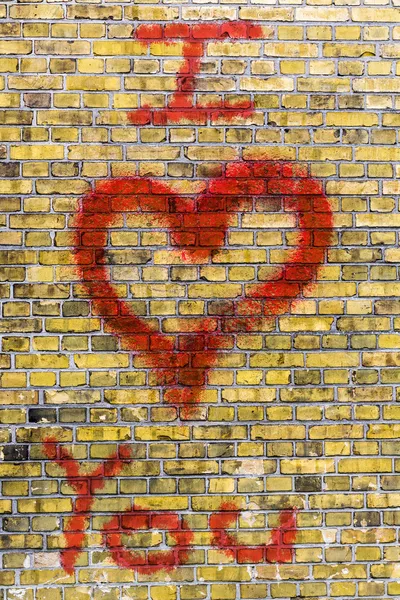 Eu te amo coração graffiti em uma parede de tijolos amarelos — Φωτογραφία Αρχείου