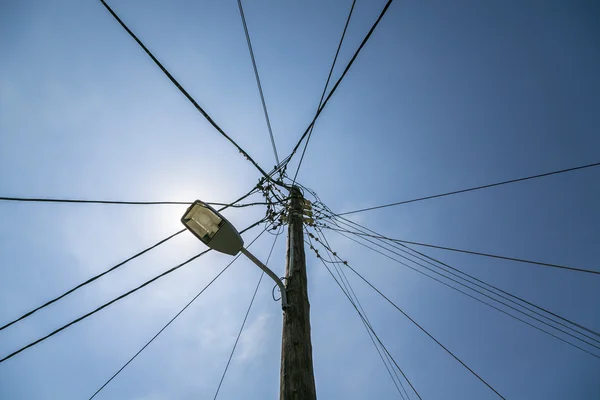 Luz de rua velha com muitos cabos conectados, isolados em sk azul — Fotografia de Stock