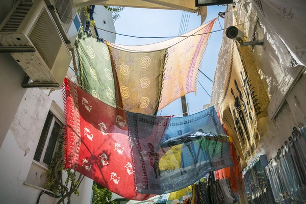 Barevné foulards visící mezi domy v podsvětlený — Stock fotografie