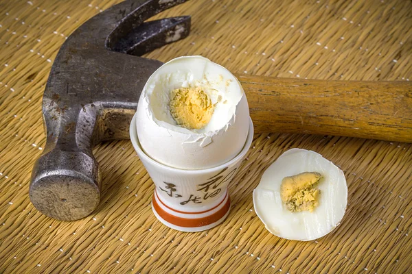 Still life with open breakfast egg and an old hammer — Stock Photo, Image