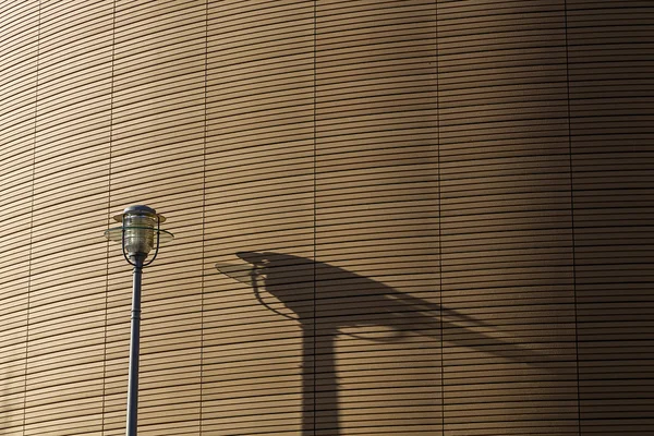 Schaduw van een straat licht op een patroon muur — Stockfoto