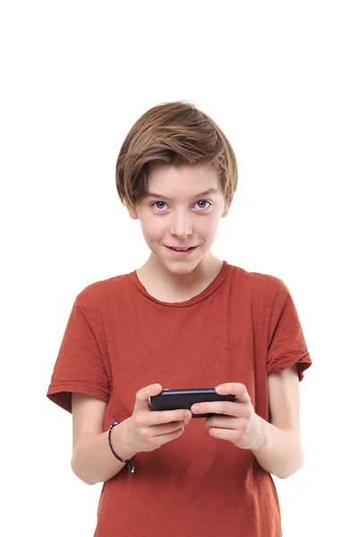 Adolescent masculin souriant avec téléphone intelligent dans les deux mains, isolé o — Photo