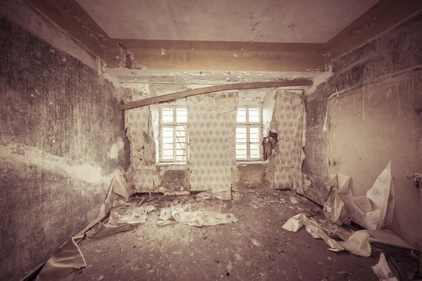 Ruinous empty room with old wallpapers and sepia color filter — Stock Photo, Image