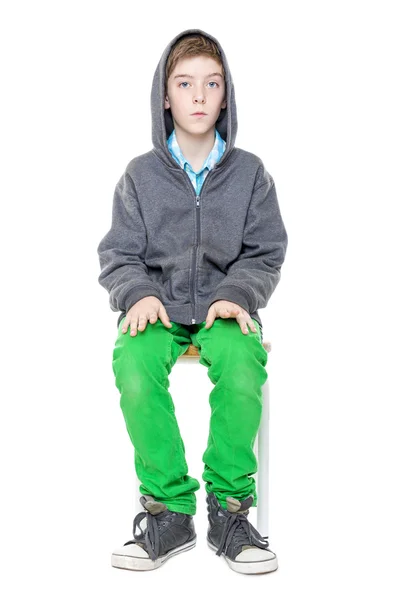 Upright sitting male teenager on a stool, isolated on white — Stock Photo, Image