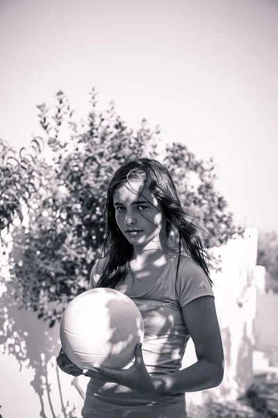 Adolescente sosteniendo una bola, blanco y negro con filtro de color — Foto de Stock