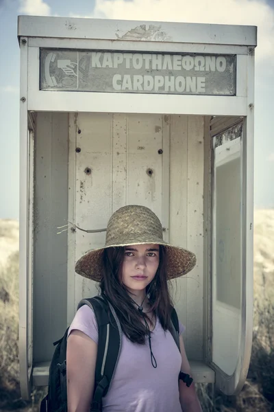 Adolescente hembra con sombrero de paja en un viejo call box — Foto de Stock