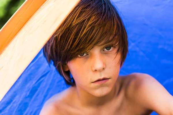 Teenager boy sitting in a tent with colored reflections — Stock Photo, Image