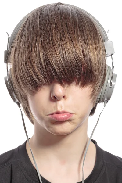 Милий хлопчик-підліток з волоссям на очах і навушниках — стокове фото