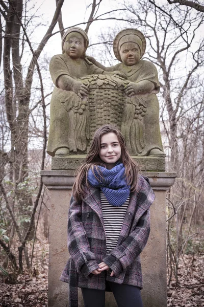 Retrato de una hermosa adolescente frente a una escultura — Foto de Stock