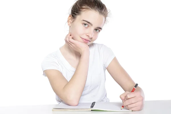 Sentada adolescente con el libro vacío abierto y lápiz, aislar — Foto de Stock