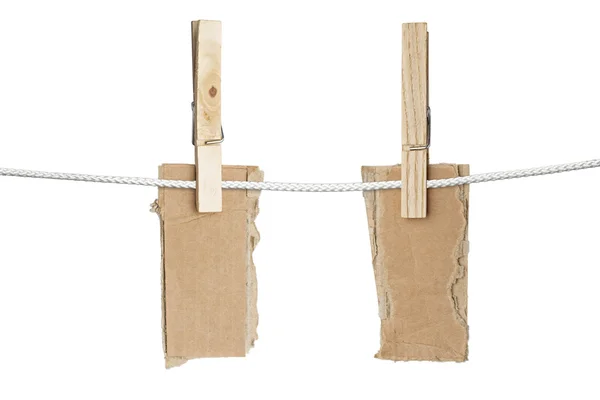 Two ripped pieces of card board hanging on one clothespins, isol — Stock Photo, Image