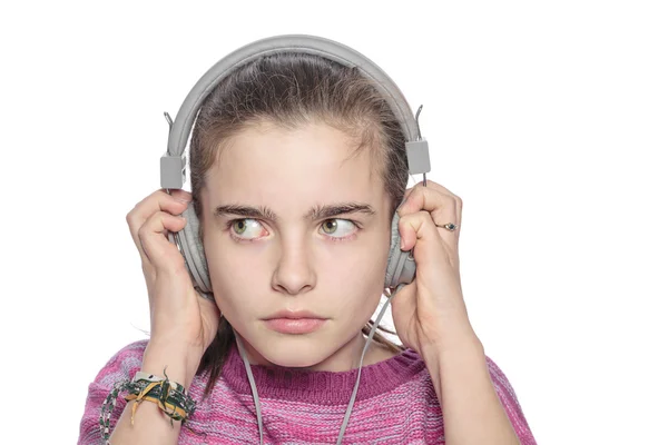 Tienermeisje hoort iets eng op koptelefoon, geïsoleerd op wh — Stockfoto