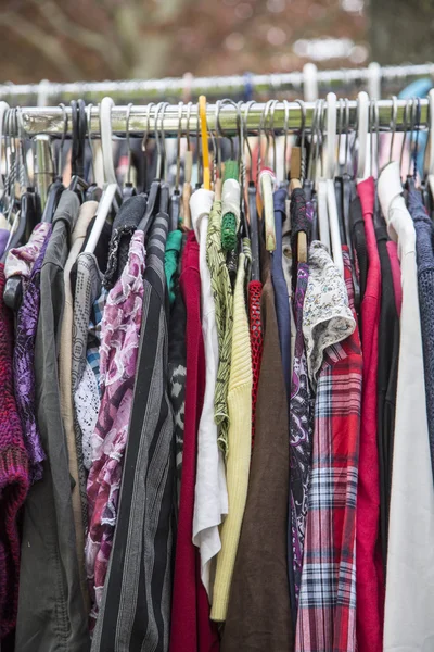 Roupas em um rack em um mercado de pulgas — Fotografia de Stock