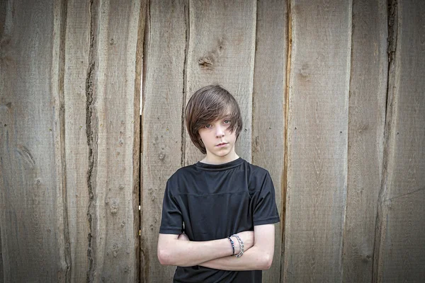 Wide angel portrait of a teenage boy in front of a wooden wall — Stock Photo, Image