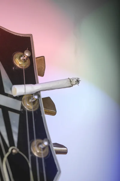 Detailní záběr Kytara vřeteník s hořící cigaretou samolepicí u — Stock fotografie