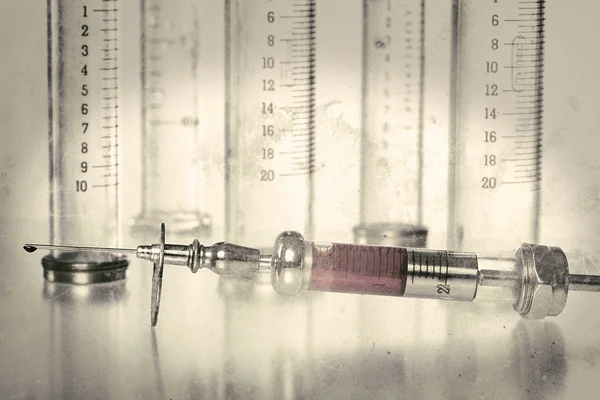 Vintage syringe with blood and empty glass syringes in backgroun — Stock Photo, Image