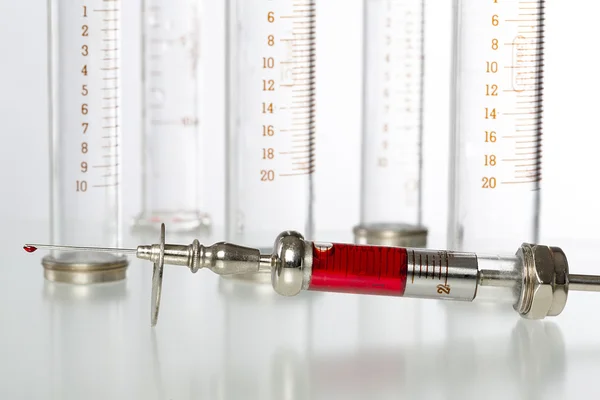 Syringe with blood and empty glass syringes in background — Stock Photo, Image