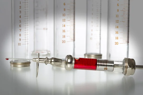 Syringe with blood and empty glass syringes in background — Stock Photo, Image