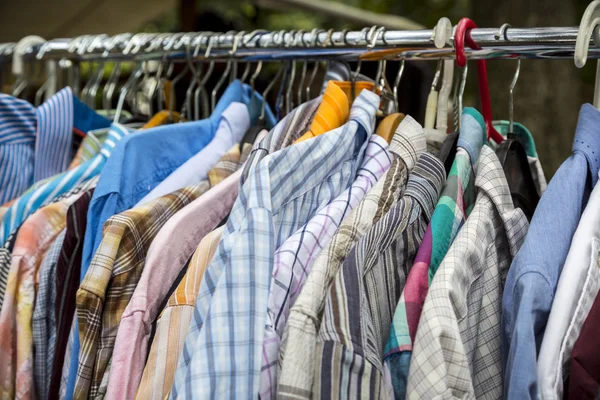 Roupas em um rack em um mercado de pulgas — Fotografia de Stock