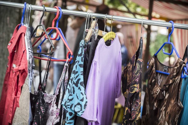 Clothes on a rack on a flea market — Stock Photo, Image