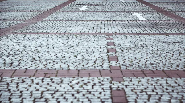 Pavimentazione in ciottoli con frecce bianche — Foto Stock