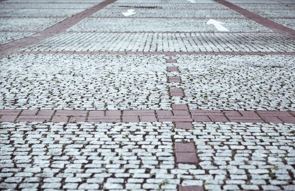 Kullerstensbelagda trottoaren med vita pilar — Stockfoto