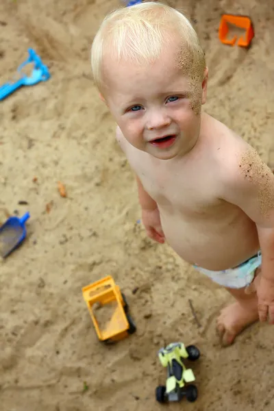 Söt baby spelar i sand — Stockfoto