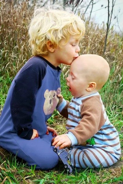 Ребенок целует младшего брата — стоковое фото