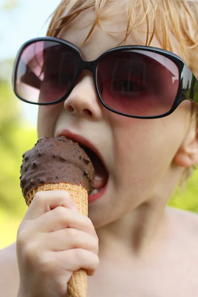 Niño en gafas de sol comiendo helado — Foto de Stock