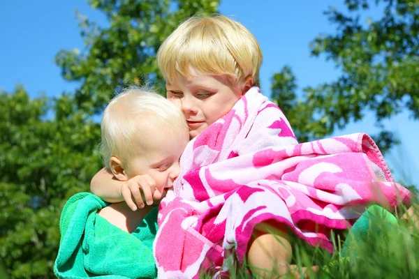 Big Brother Hugging Baby Outside in Beach Towels — Stock Photo, Image