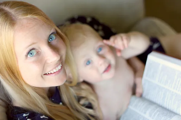 Женщина читает с младенцем на лапе — стоковое фото