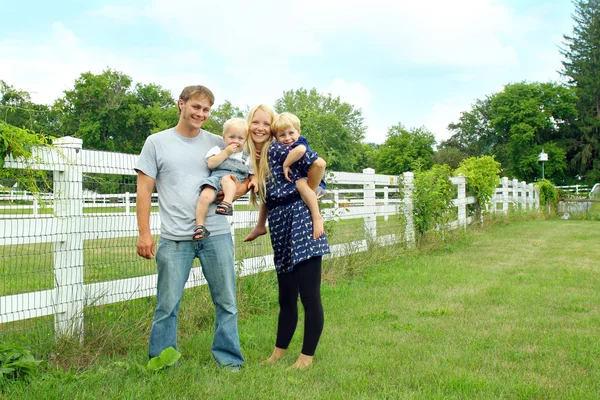 Glückliche Familie draußen am weißen Zaun — Stockfoto