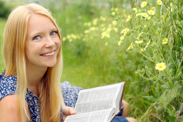 Kvinna läsa Bibeln utanför — Stockfoto