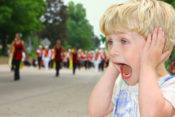 Barn täcker öronen under högljudd parad — Stockfoto