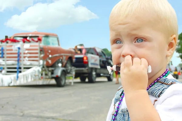 Bebé comiendo caramelo en el desfile —  Fotos de Stock