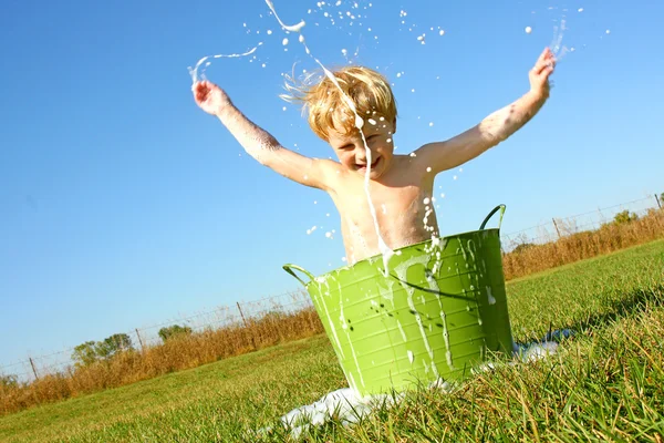 Kind spritzt Wasser und Blasen in Badewanne — Stockfoto