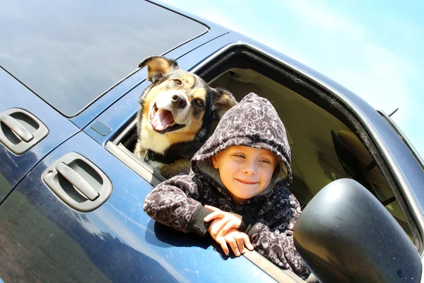 少年と彼の犬のミニバンの窓の外にぶら下がっています。 — ストック写真