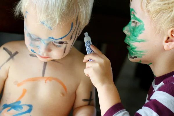 Niño pequeño para colorear cara de hermano bebé — Foto de Stock