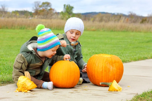 Dos niños pequeños tallando calabazas — Foto de Stock