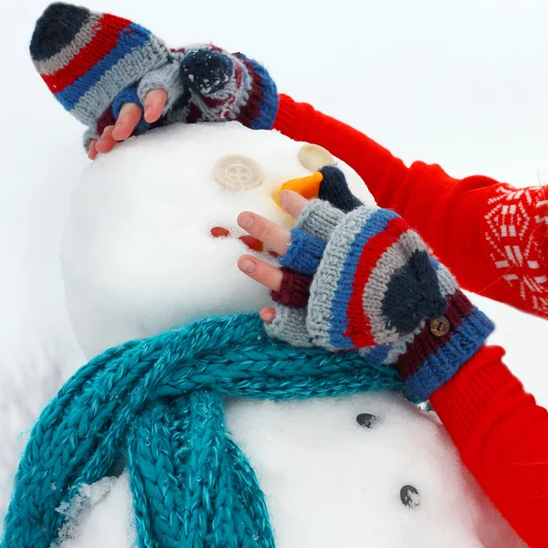 Mãos construindo boneco de neve fora no inverno — Fotografia de Stock