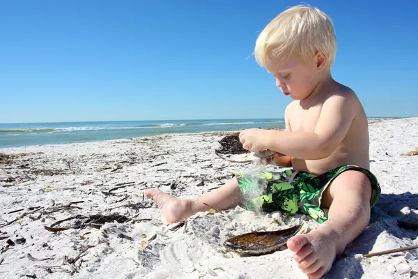 Jong kind spelen in het zand op het strand — Stockfoto