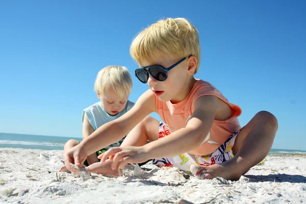 Två barn som leker i sanden på stranden — Stockfoto