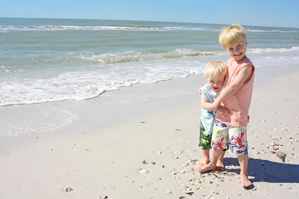 Felizes jovens irmãos posando na praia — Fotografia de Stock