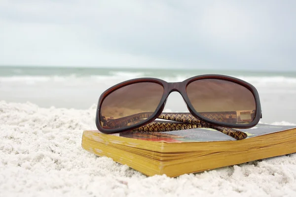 Óculos de sol em Book at Beach — Fotografia de Stock